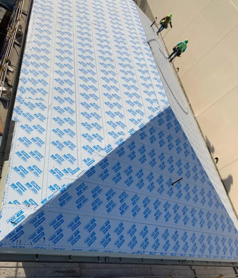 Professional roofers installing underlayment on a metal roof in Orland Hills